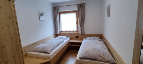 a room with two beds in front of a window at Apartments Goller in Ortisei