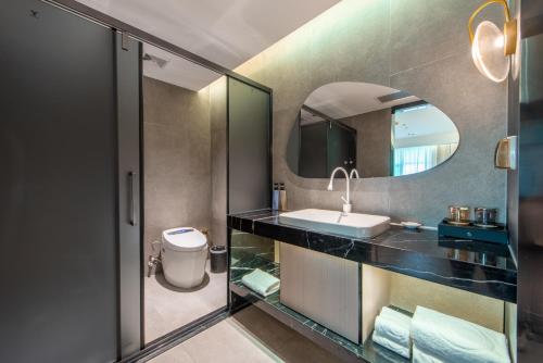 a bathroom with a sink and a mirror at Calvin International Hotel Guangzhou Baiyun International Airport Huadu Plaza Branch - Free Deliver Service to Guangzhou Baiyun International Airport & Free Deliver Service to Canton Fair Complex During Canton Fair Period in Huadu