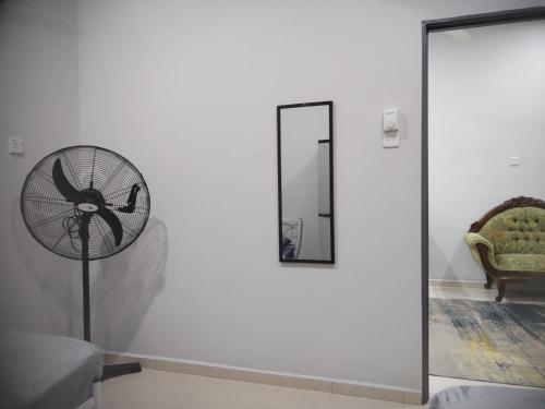 a clock on a wall in a room with a mirror at Kenangan Homestay Kemaman in Kampong Chendar