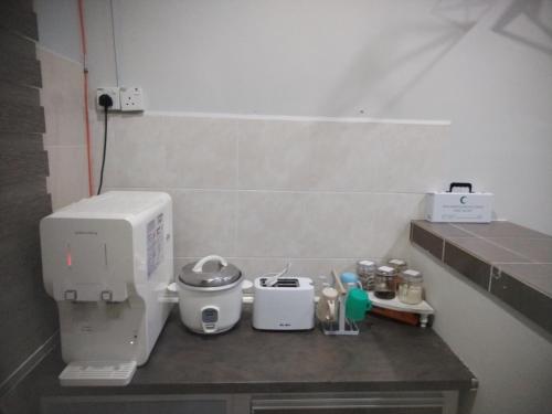 a kitchen counter with a coffee maker on it at Kenangan Homestay Kemaman in Kampong Chendar