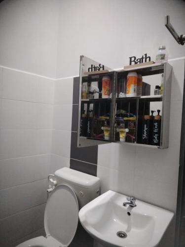 a bathroom with a toilet and a sink at Kenangan Homestay Kemaman in Kampong Chendar