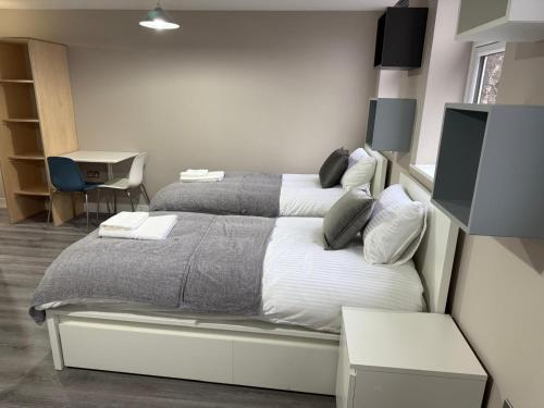 a bedroom with two beds and a desk at Ryegate House Colchester in Colchester