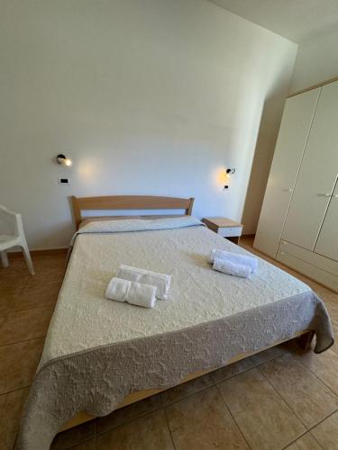 a bedroom with a bed with two towels on it at Case vacanza Corallo - San Teodoro centro in San Teodoro