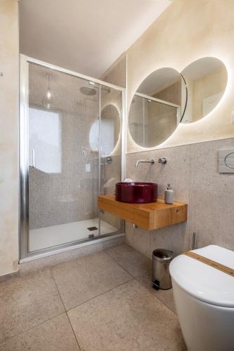 a bathroom with a shower and a toilet and a sink at La Bartolomea Home & Suite in Pitigliano