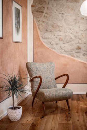 a chair in a room with a potted plant at La Bartolomea Home & Suite in Pitigliano