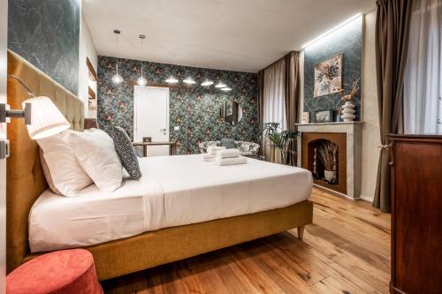 a bedroom with a bed and a fireplace at La Bartolomea Home & Suite in Pitigliano