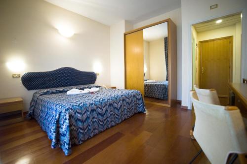 a bedroom with a bed and a dresser at Hotel Villa Ricci & Benessere in Chianciano Terme