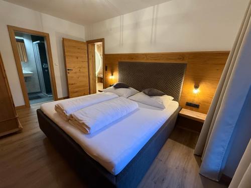 a bedroom with a large bed with white sheets at Residence Alpin in Zell am Ziller