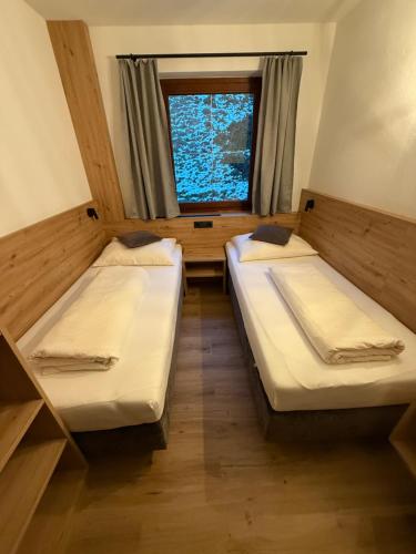 two beds in a small room with a window at Residence Alpin in Zell am Ziller