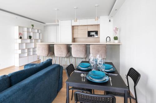 un salon avec un canapé bleu et une table dans l'établissement Lumineux 2 chambres avec Terrasse, à Paris