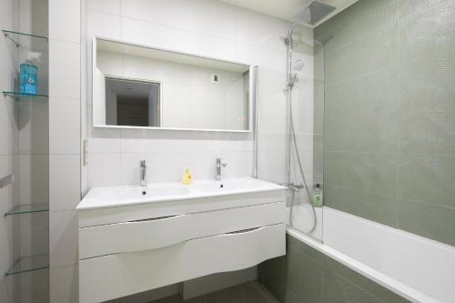 une salle de bain avec un lavabo, un miroir et une baignoire dans l'établissement Lumineux 2 chambres avec Terrasse, à Paris