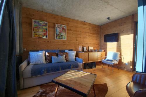 un salon avec un canapé bleu et une table dans l'établissement Appartement Ours Blanc - Welkeys, à Huez