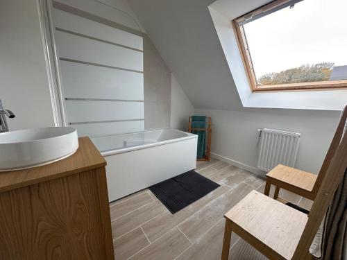 une salle de bain avec un lavabo et une baignoire dans l'établissement La Brise Marine, à Barneville-Carteret