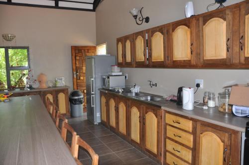 een keuken met houten kasten en een aanrecht bij Thorntree Lodge in Potchefstroom