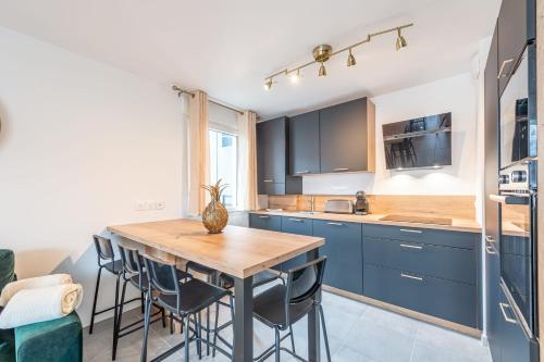 une cuisine avec des placards bleus et une table en bois dans l'établissement ANNECITY - Appartement confortable près du centre ville, à Annecy