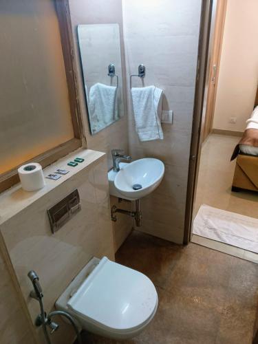 un bagno con un water bianco e un lavandino di Soooper Hotel a Gurgaon