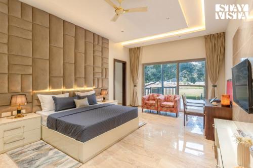 a bedroom with a king sized bed and a desk at StayVista at Villa Solace with Lawn in Chandīgarh