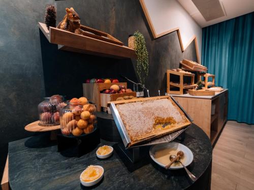 Un buffet con comida en una mesa en una habitación. en Golden Tulip Aix les Bains - Hotel & Spa, en Aix-les-Bains