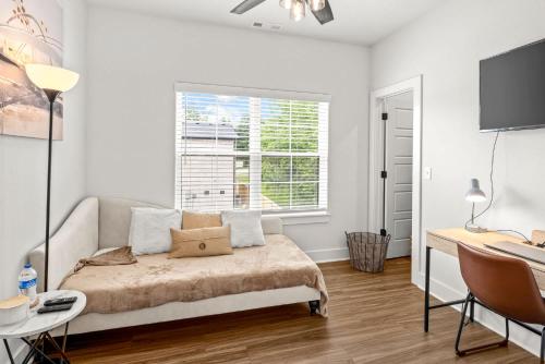 a bedroom with a bed and a desk and a window at Stylish 2BR Home Near University of Arkansas in Fayetteville