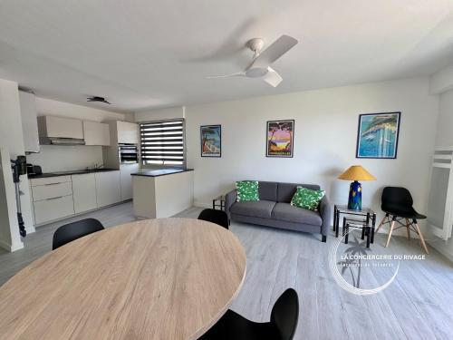 un salon avec une table et un canapé dans l'établissement Le Frangipanier - Port de Carqueiranne et plages, à Carqueiranne