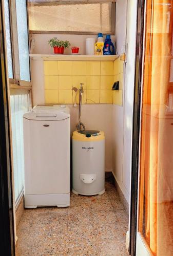 a small bathroom with a washer and dryer in it at Bohemia Baires Balvanera in Buenos Aires