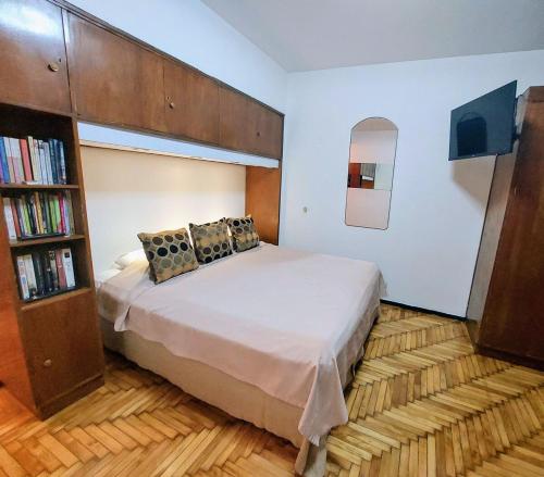 a bedroom with a bed and a book shelf at Bohemia Baires Balvanera in Buenos Aires