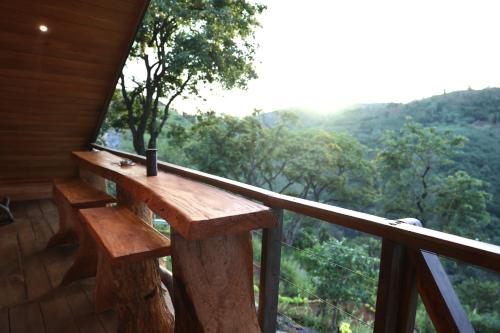 a wooden bench on a balcony with a view at Paradise Point Nature Cabana Kandy in Kande
