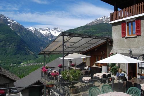 a balcony of a building with tables and umbrellas at Osteria Anzonico in Anzonico