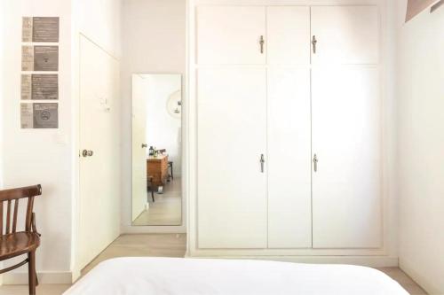 a bedroom with white cabinets and a mirror at Wood&Stone Rooms - Eywa Hogar in Yecla