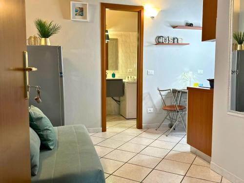 a kitchen and a living room with a table and a refrigerator at Domus Derthona Alloggio Sarina in Tortona