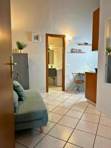 a living room with a couch and a kitchen at Domus Derthona Alloggio Sarina in Tortona