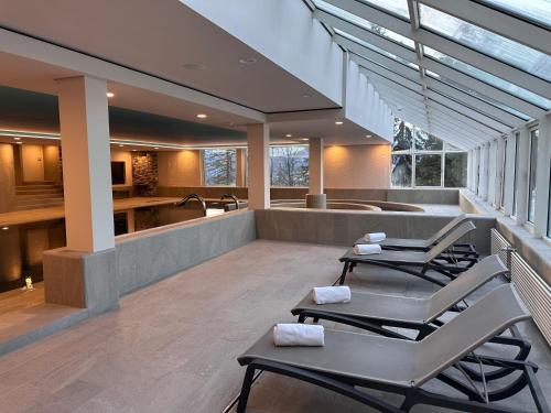 a patio with chairs and a tub in a house at Hotel Valaisia Crans Montana, a Faern Collection Resort in Crans-Montana