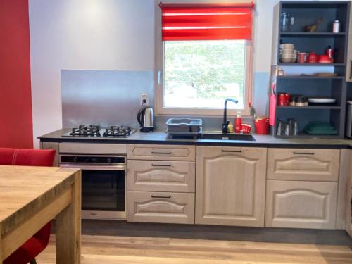 a kitchen with a stove top oven next to a window at Chalet du hérisson in Ménétrux-en-Joux