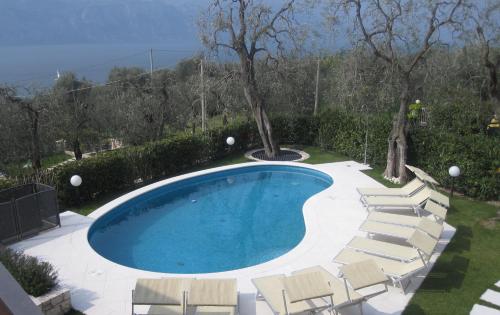 ein Pool mit Liegestühlen um ihn herum in der Unterkunft Appartamenti Chemasi in Brenzone sul Garda