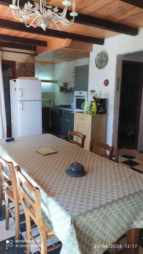 Il comprend une cuisine équipée d'une table avec des chaises et d'un réfrigérateur blanc. dans l'établissement maison de campagne, à La Roque-sur-Cèze