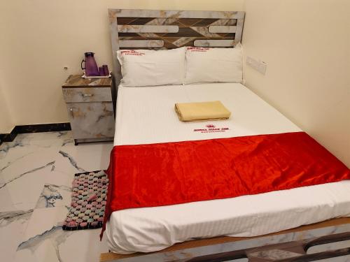 a bed with a red blanket on top of it at Hotel SONIA MAHI INN KANYAKUMARI in Kanyakumari