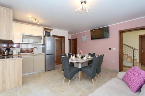 a kitchen and a dining room with a table and chairs at Apartment ErMa in Zaton