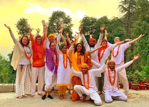 Un gruppo di persone che posano per una foto con le mani in alto di Om Yoga Ashram - 7 Days Yoga Meditation Retreat a Dharamshala