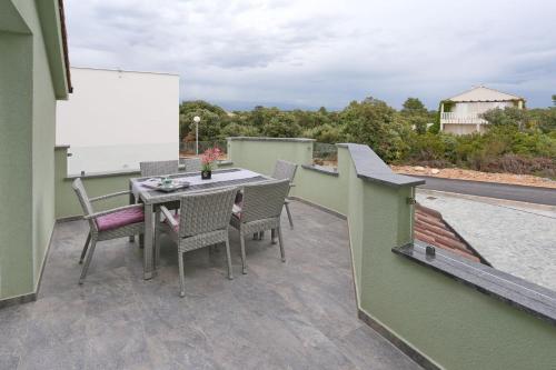 a patio with a table and chairs on a balcony at Apartment ErMa in Zaton