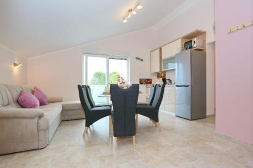 a kitchen and living room with a table and chairs at Apartment ErMa in Zaton