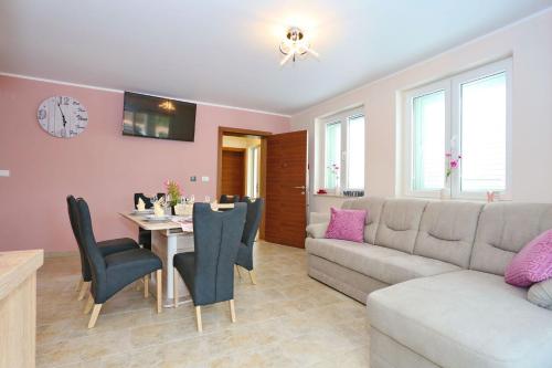 a living room with a couch and a table with chairs at Apartment ErMa in Zaton