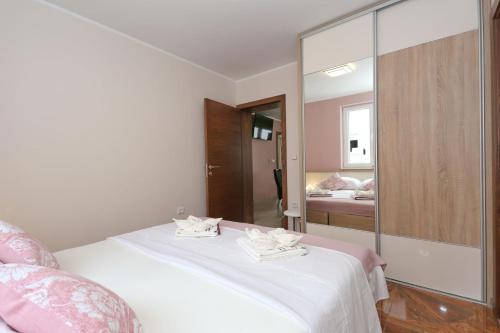 a bedroom with a white bed and a mirror at Apartment ErMa in Zaton
