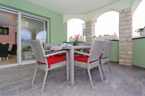 a dining room with a table and wicker chairs at Apartment ErMa in Zaton