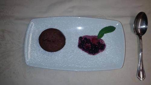a white plate with a chocolate cookie and a desert at Osteria Anzonico in Anzonico