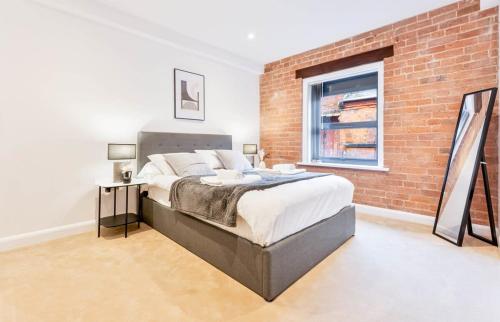 a bedroom with a brick wall and a large bed at Stunning 2 Bed Apartment in Burton-on-Trent in Burton upon Trent
