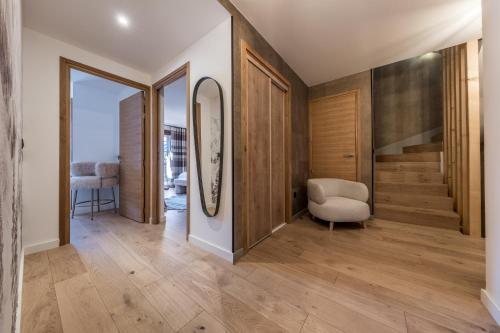 a hallway with wood floors and a stairway with a chair at Le Glacier Pelve Courchevel 1650 - Five Bedrooms - Bed & Breakfast in Courchevel