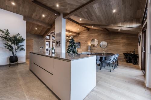 an open kitchen and dining room with a dining table at Le Glacier Pelve Courchevel 1650 - Five Bedrooms - Bed & Breakfast in Courchevel