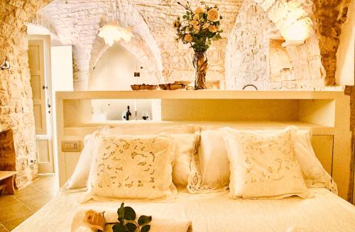 a bedroom with a large white bed with pillows at DeaDomus 55 in Cisternino
