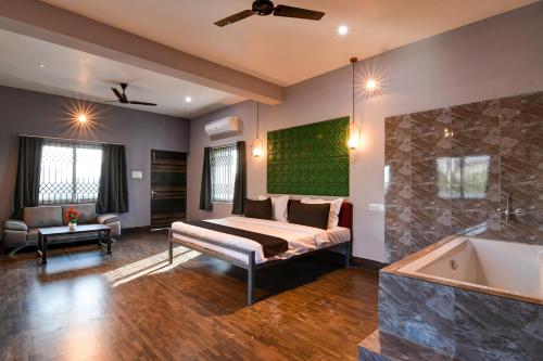 a bedroom with a bed and a bathtub and a room with a tub at Hotel O Neatflix &Chill in Khandagiri