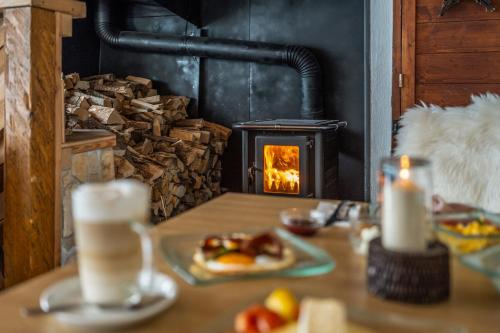 a table with a plate of food and a fireplace at Panorama Hotel Guggenbichl - inkl Sommerkarte, einmaliger Eintritt ins Tauern Spa & bester Ausblick über Kaprun in Kaprun